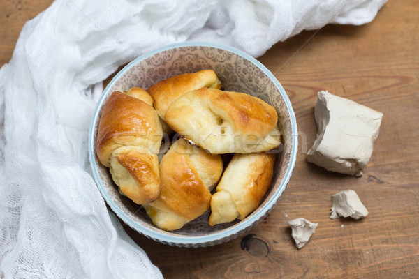 homemade yeast croissants in a ceramic bowl and raw yeast on a wooden background Stock photo © laciatek