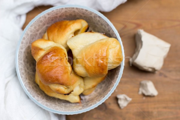 homemade yeast croissants in a ceramic bowl and raw yeast on a wooden background Stock photo © laciatek