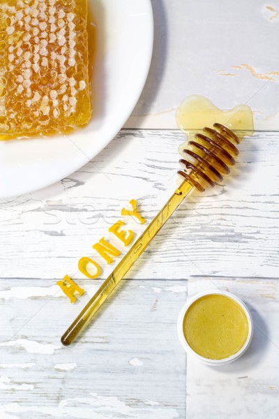 tasty organic honey in a honeycomb and honey lip balm on a wooden, vintage background Stock photo © laciatek