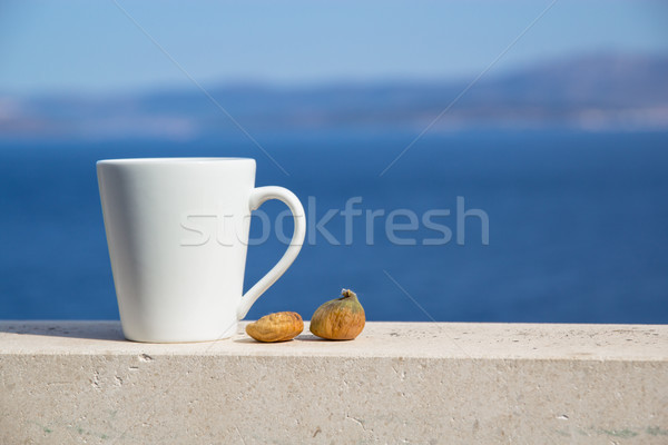 white cup with coffee and two figs on a background of blue sea and mountains Stock photo © laciatek