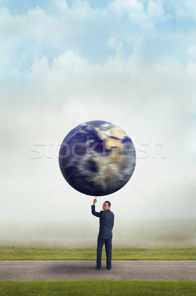 businessman holding planet earth with one finger  Stock photo © leeavison