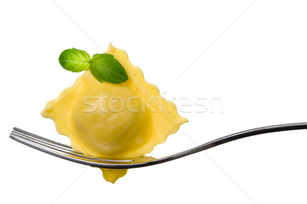ravioli pasta parcel and basil garnish on fork white background Stock photo © leeavison