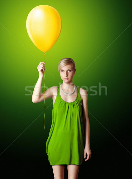 blonde in green dress with the yellow balloon Stock photo © leedsn