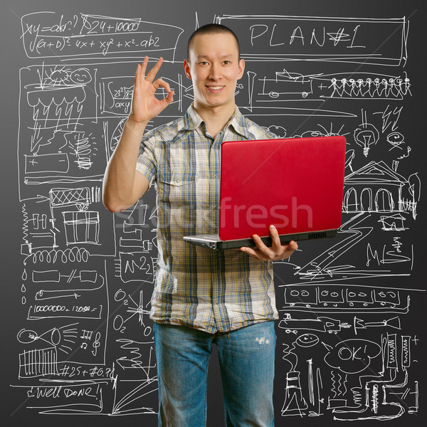 asian male with laptop in his hands shows OK Stock photo © leedsn