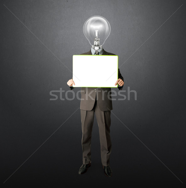 happy businessman with lamp-head holding card Stock photo © leedsn