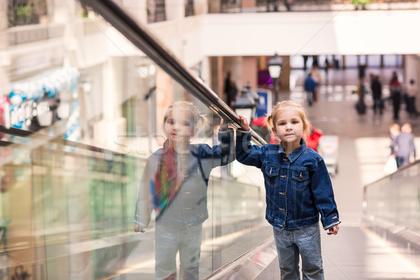 Cute little child in shopping center standing on moving escalator Stock photo © Len44ik