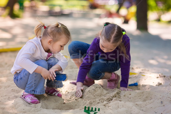 Stock photo: Happy little girls playing in a sendbox