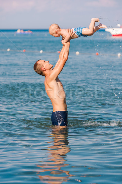 Happy father and baby having fun in the sea Stock photo © Len44ik