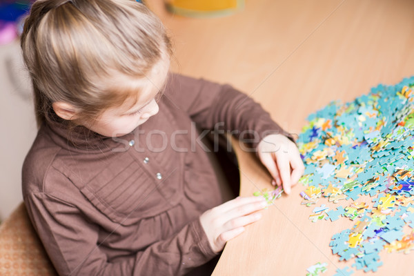 Cute little girl solving puzzles Stock photo © Len44ik