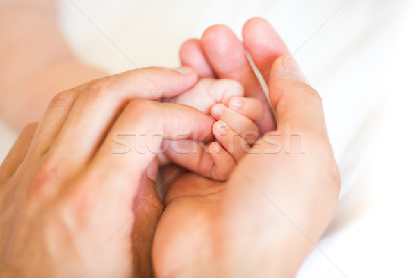 Stock photo: Father holding the hand of his new born son
