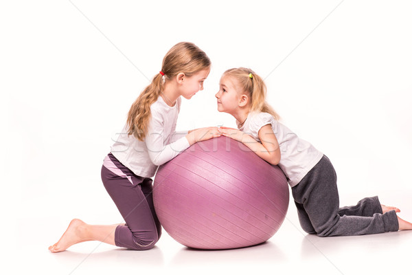 Stock photo: Sportive girls on a fit ball isolated over white