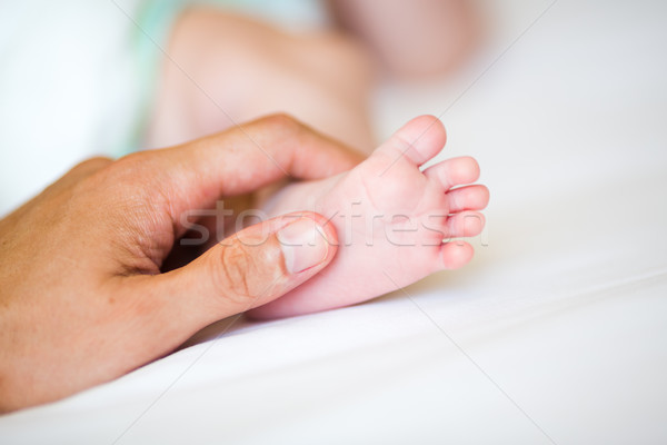 Father holding the foot of his new born son Stock photo © Len44ik