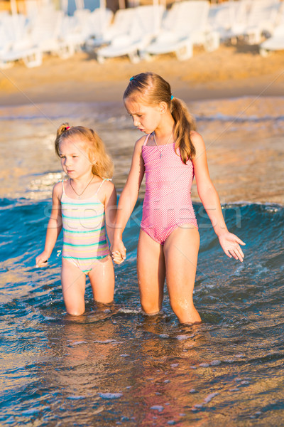 Stock photo: Two adorable kids playing in the sea on a beach