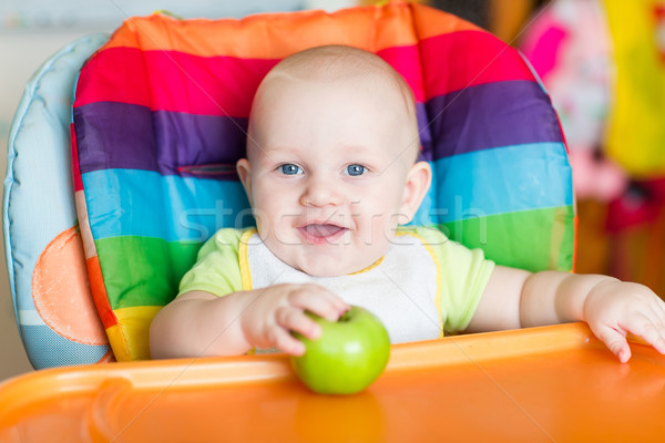 Stock photo: Adorable baby eating in high chair