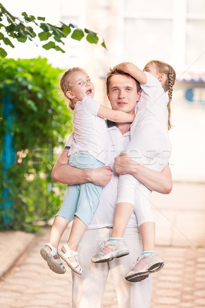 Stock photo: Happy young father holding his kids outdoor