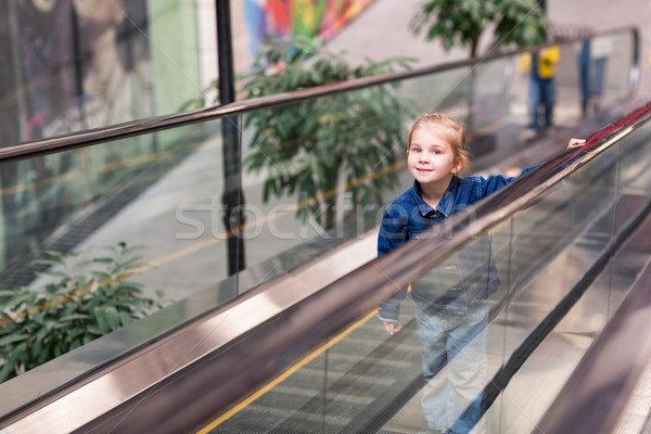 Cute little child in shopping center standing on moving escalator Stock photo © Len44ik