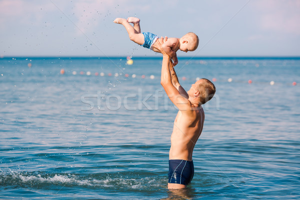 Stock photo: Happy father and baby having fun in the sea