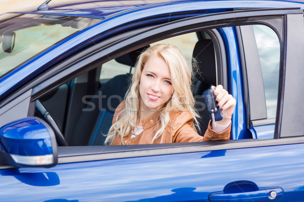 Stock photo: Beautiful happy young girl sitting in the car