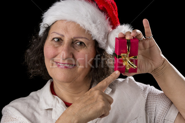 Stock photo: Smiling Aged Woman Holding and Pointing at Red Gift