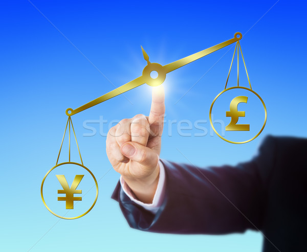 Yen Sign Outweighing The Pound On A Golden Scale Stock photo © leowolfert