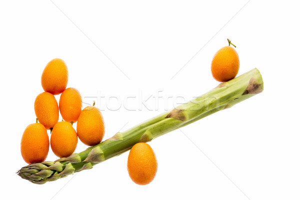 Seesaw Made From One Asparagus and Eight Kumquats Stock photo © leowolfert