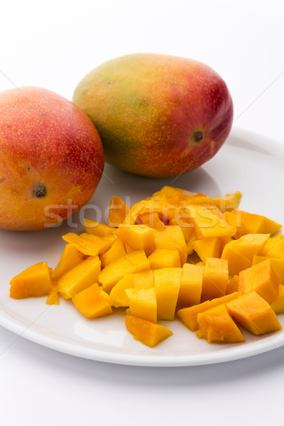 Mango Cubes And Two Whole Mangos On A White Plate Stock photo © leowolfert