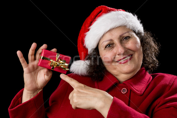 Joyful Aged Lady Pointing at Red Christmas Gift
 Stock photo © leowolfert
