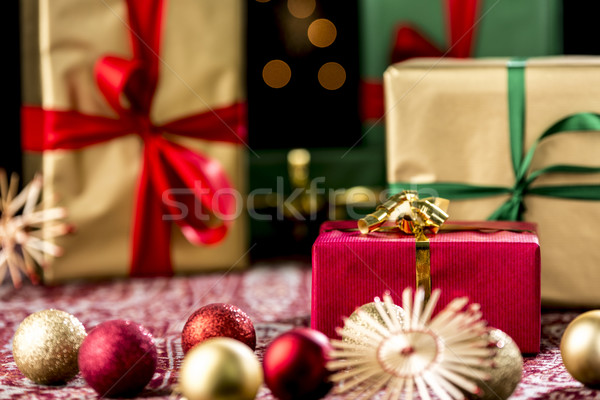 Red Christmas Gift Amidst Baubles and Stars Stock photo © leowolfert