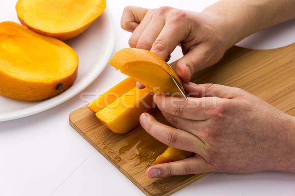 Two Male Hands Peeling A Juicy Mango Fruit Chip Stock photo © leowolfert