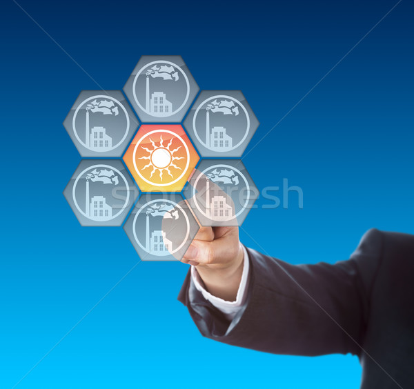 Business Hand Activating Solar Power Icon On Blue Stock photo © leowolfert