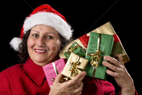 Mature Lady Holding Up Five Christmas Presents
 Stock photo © leowolfert