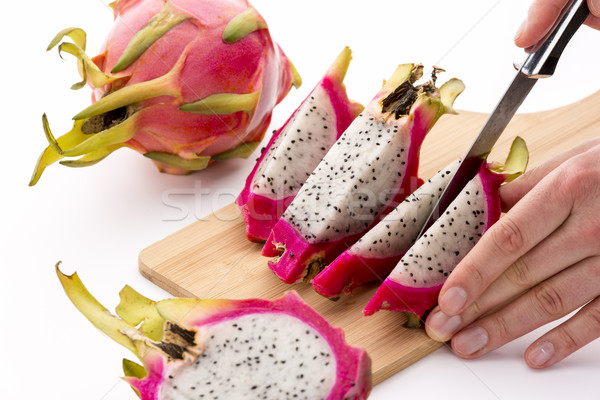 Cutting A Halved Pitaya Into Four Fruit Wedges Stock photo © leowolfert