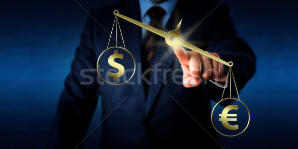 Euro Sign Outweighing The Dollar On Golden Scale Stock photo © leowolfert