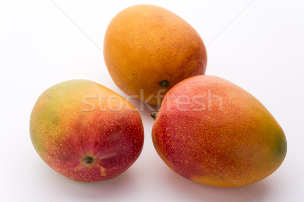 Three Ripe Mangos With Impeccable Skin On White Stock photo © leowolfert