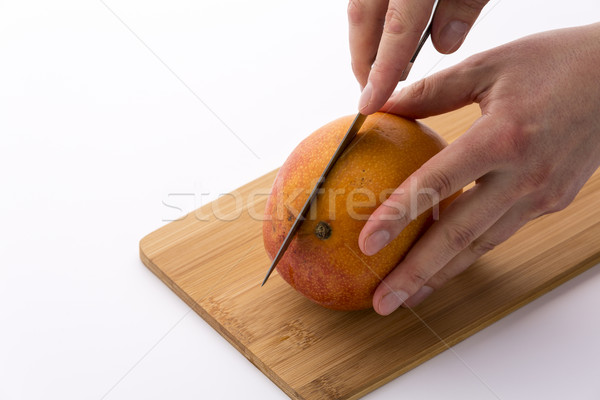 Kitchen Knife Sinking Into Mango For A First Cut Stock photo © leowolfert