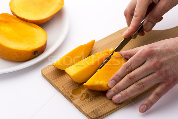 Mango Divided Into Thirds Being Subdivided Further Stock photo © leowolfert
