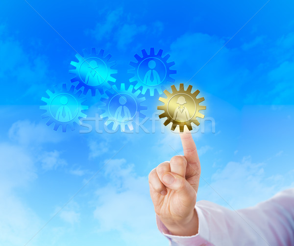 Stock photo: Hand Selecting A Golden Cog With A Female Worker