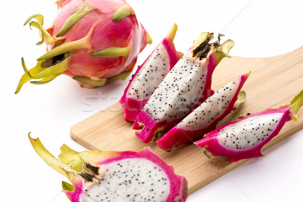 Four Fruit Wedges Of A Cut Pitaya On Cutting Board Stock photo © leowolfert