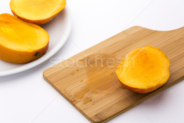Third Of A Mango And Its Juice On Wooden Board Stock photo © leowolfert