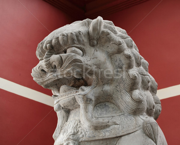 stone lion statue before the red wall Stock photo © leungchopan