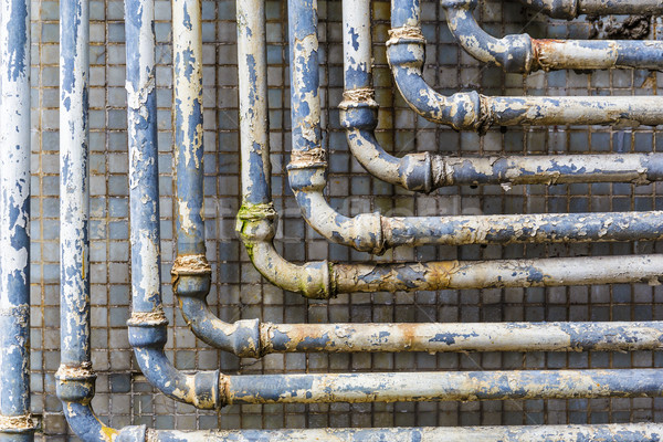 Series of parallel old pipes on wall Stock photo © leungchopan