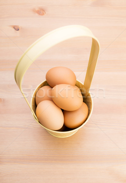 Brown egg in bucket with wooden background Stock photo © leungchopan