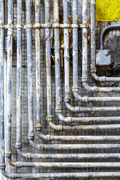 Series of parallel old pipes on wall Stock photo © leungchopan