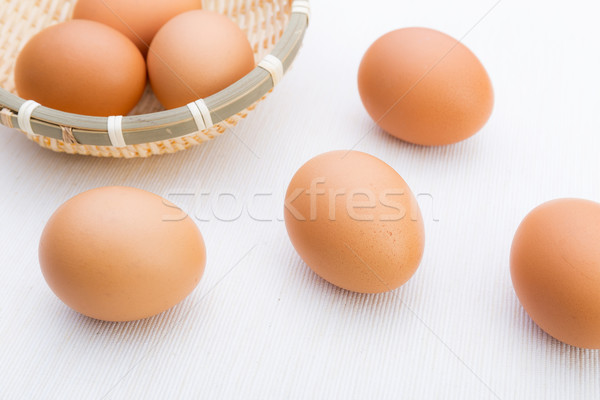 Stock photo: Brown egg in basket isolated on white