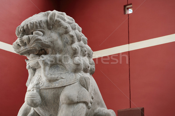 stone lion statue before the red wall Stock photo © leungchopan