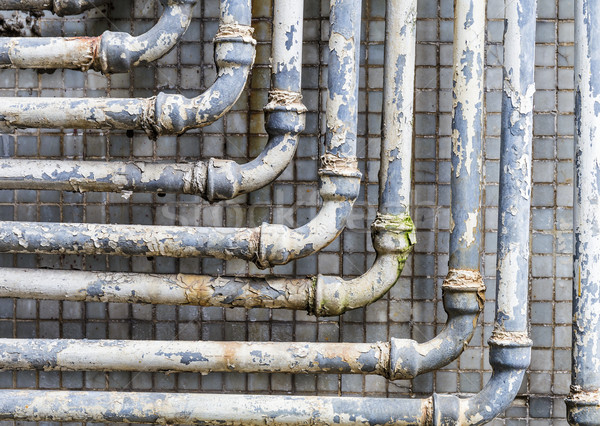 Series of parallel old pipes on wall Stock photo © leungchopan
