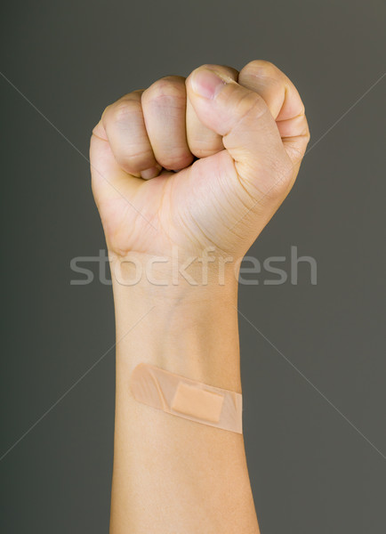 Clenched fist with plaster Stock photo © leungchopan