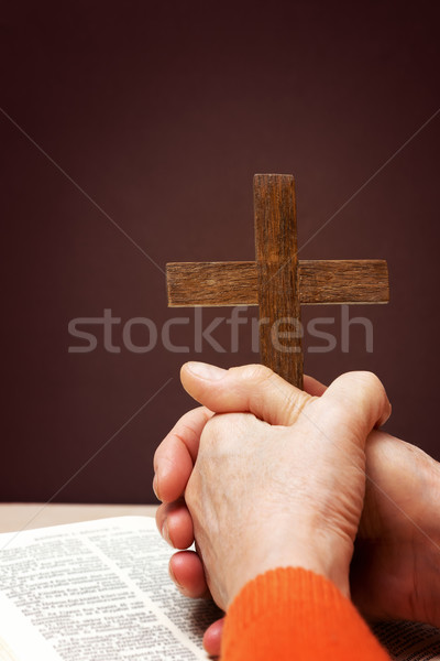 Wooden Christian cross and hand next on holy Bible Stock photo © leventegyori