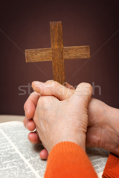 Closeup of wooden Christian cross and hand next on holy Bible Stock photo © leventegyori