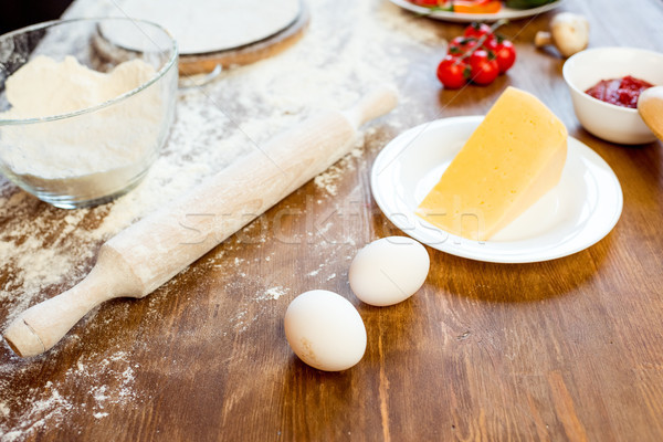 different pizza ingredients, eggs and cheese on wooden tabletop Stock photo © LightFieldStudios